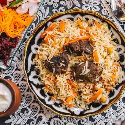 top-view-rice-with-carrot-cooked-with-lamb-served-with-yogurt-salad_141793-2449