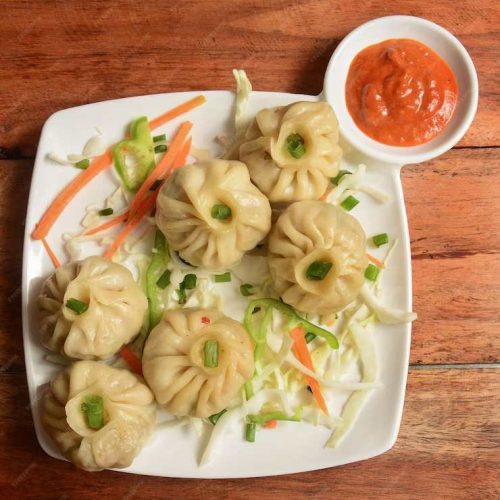 veg-steam-momo-nepalese-traditional-dish-momo-stuffed-with-vegetables-then-cooked-served-with-sauce-rustic-wooden-background-selective-focus_726363-879